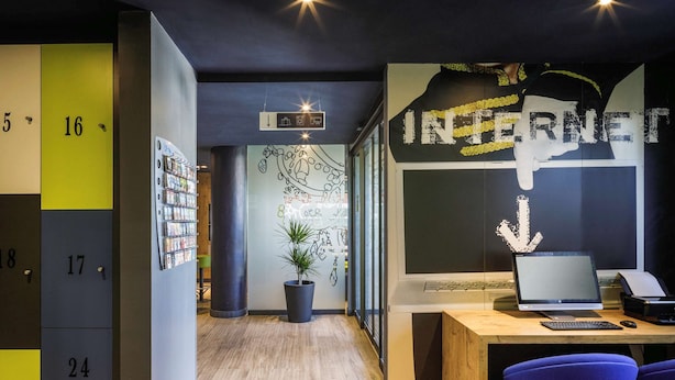 Un espacio de oficina moderno con suelo de madera, un escritorio con una computadora portátil y un letrero grande que dice
