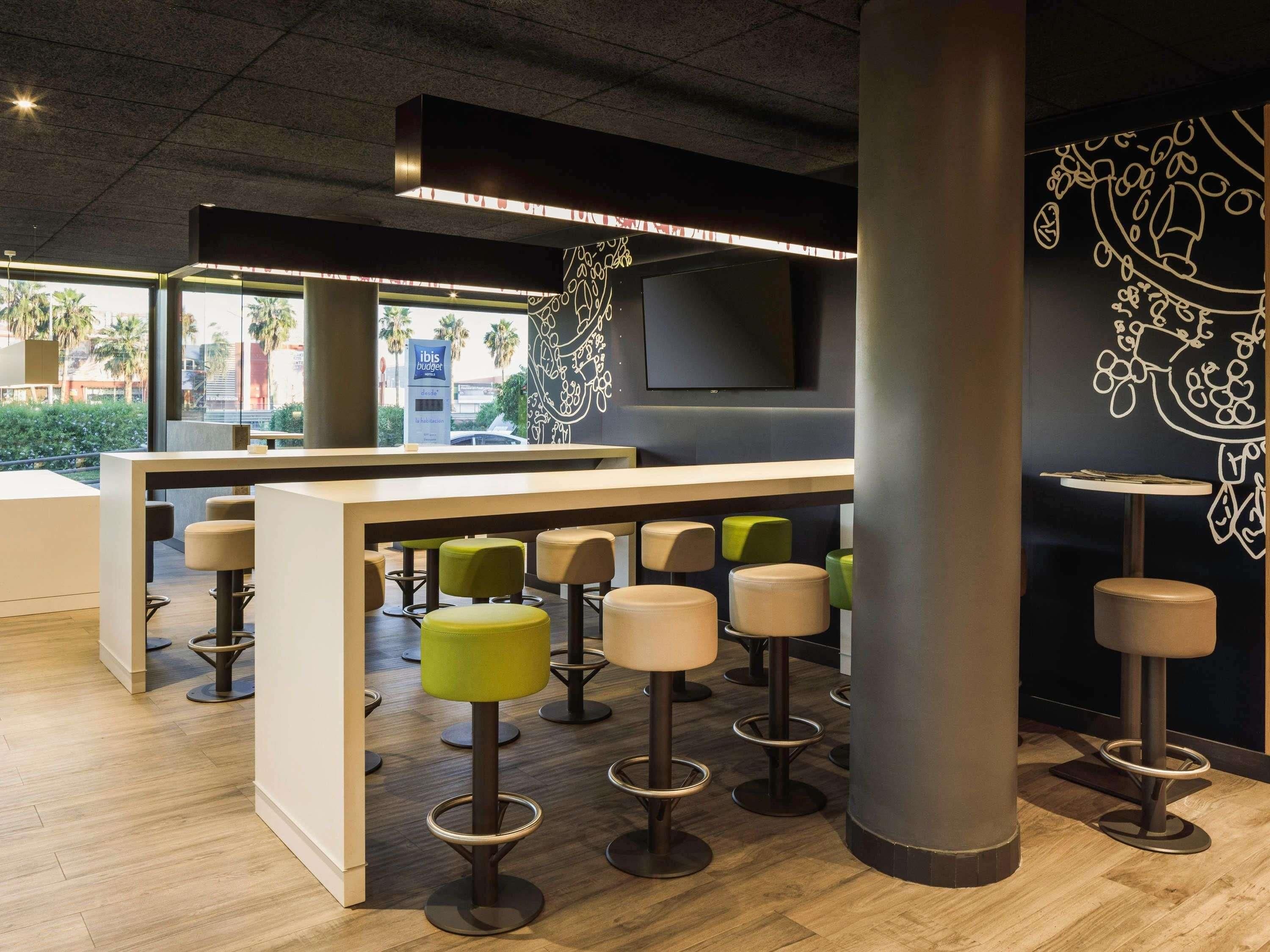 Een moderne bar met hoge krukken, een toonbank en een grote pilaar.