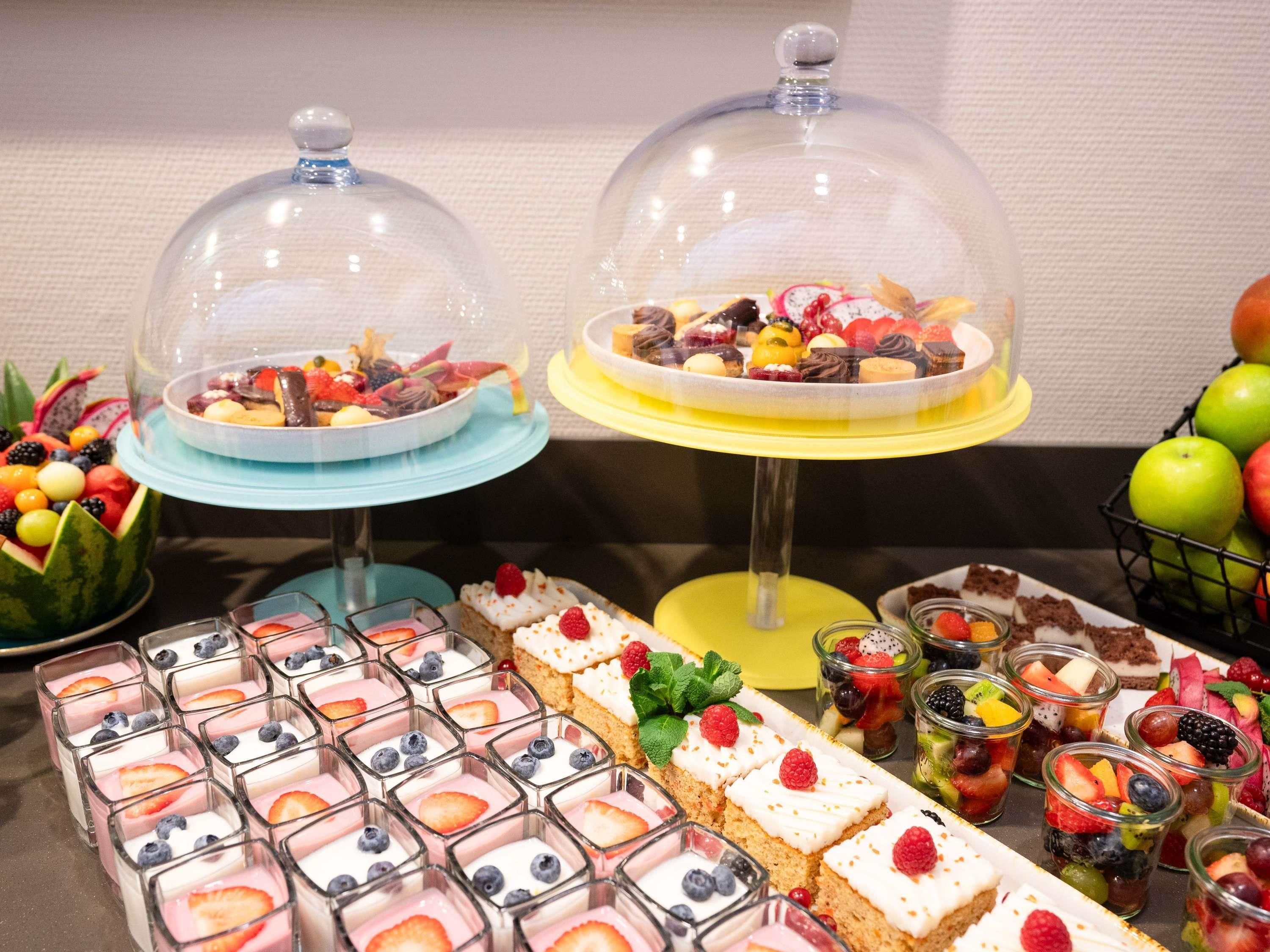 A buffet with various desserts and fruits.