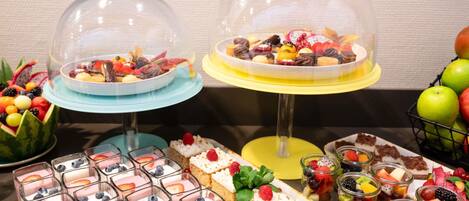 A buffet with various desserts and fruits.
