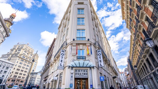 Un hotel alto de estilo arquitectónico clásico, con varios balcones y una entrada destacada.