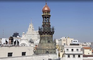 A historic building with a prominent tower featuring a copper dome and ornate decorations. - Hotel Quatro Puerta Del Sol (Madrid)