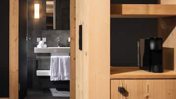 Un baño moderno con tocador de madera, lavabo y espejo.