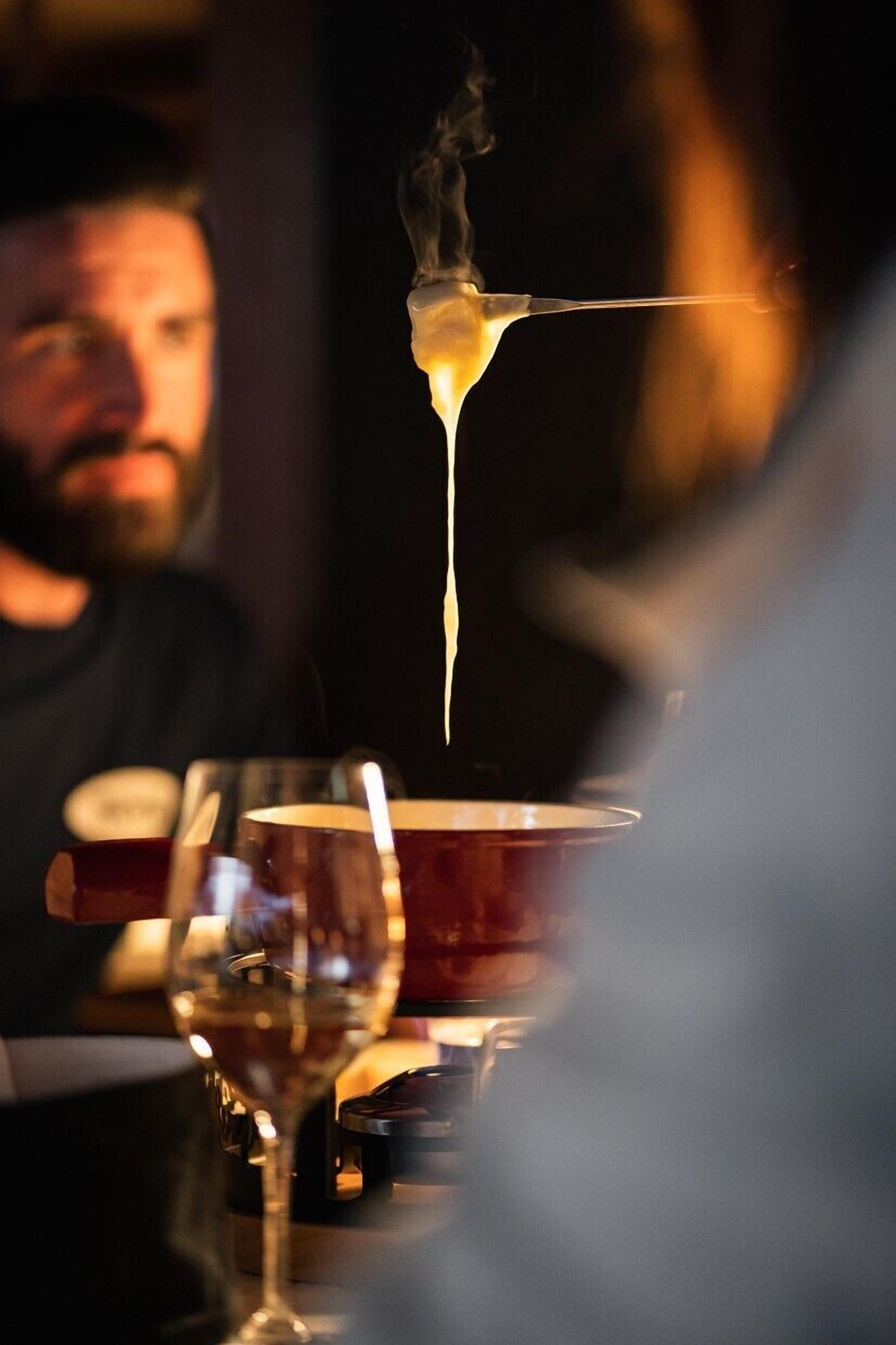 A close-up of a glass with a clear liquid and a visible stream of vapor, suggesting a hot beverage or a cocktail being prepared.