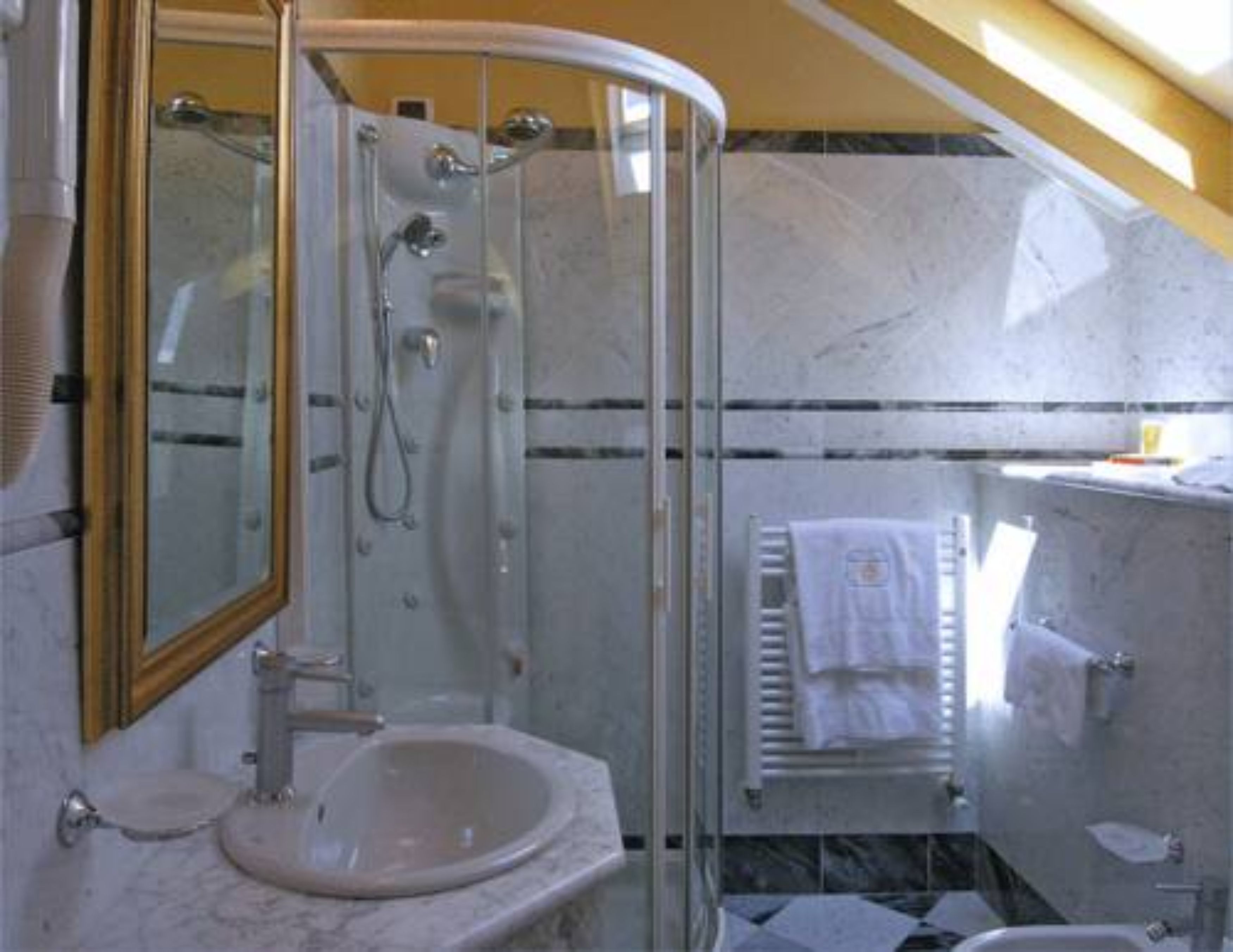 Ein Badezimmer mit Duschkabine, Waschbecken und Handtuchhalter.