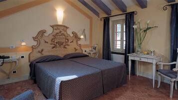 Un dormitorio con una cama grande, un escritorio con silla y una ventana con cortinas.