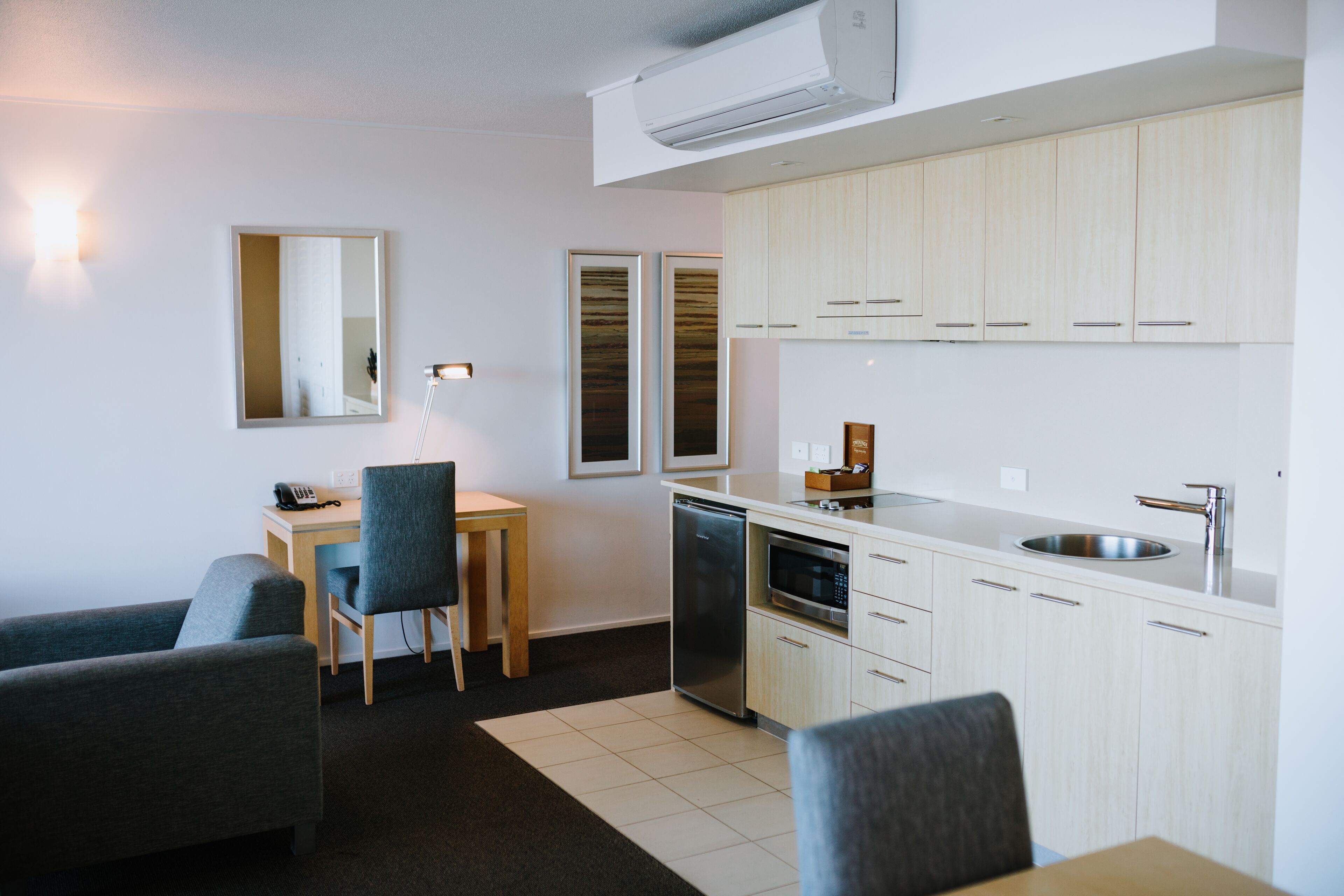 A modern kitchen with white cabinets, a built-in dishwasher, and a stainless steel sink.