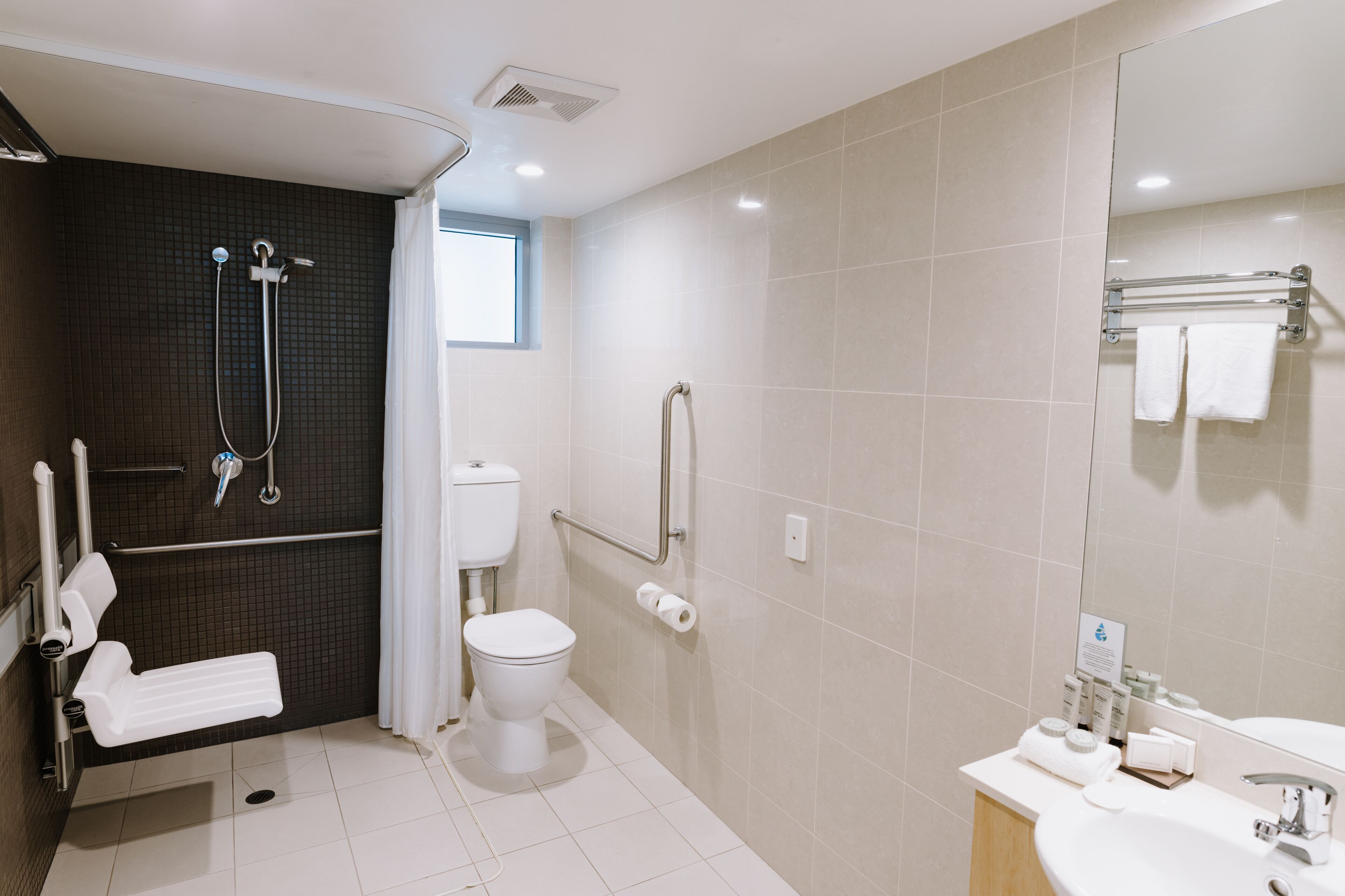 A modern bathroom with a shower, toilet, and sink.