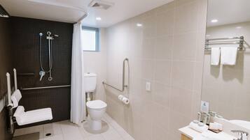 A modern bathroom with a shower, toilet, and sink.