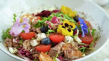 A bowl of salad with various vegetables and cheese.