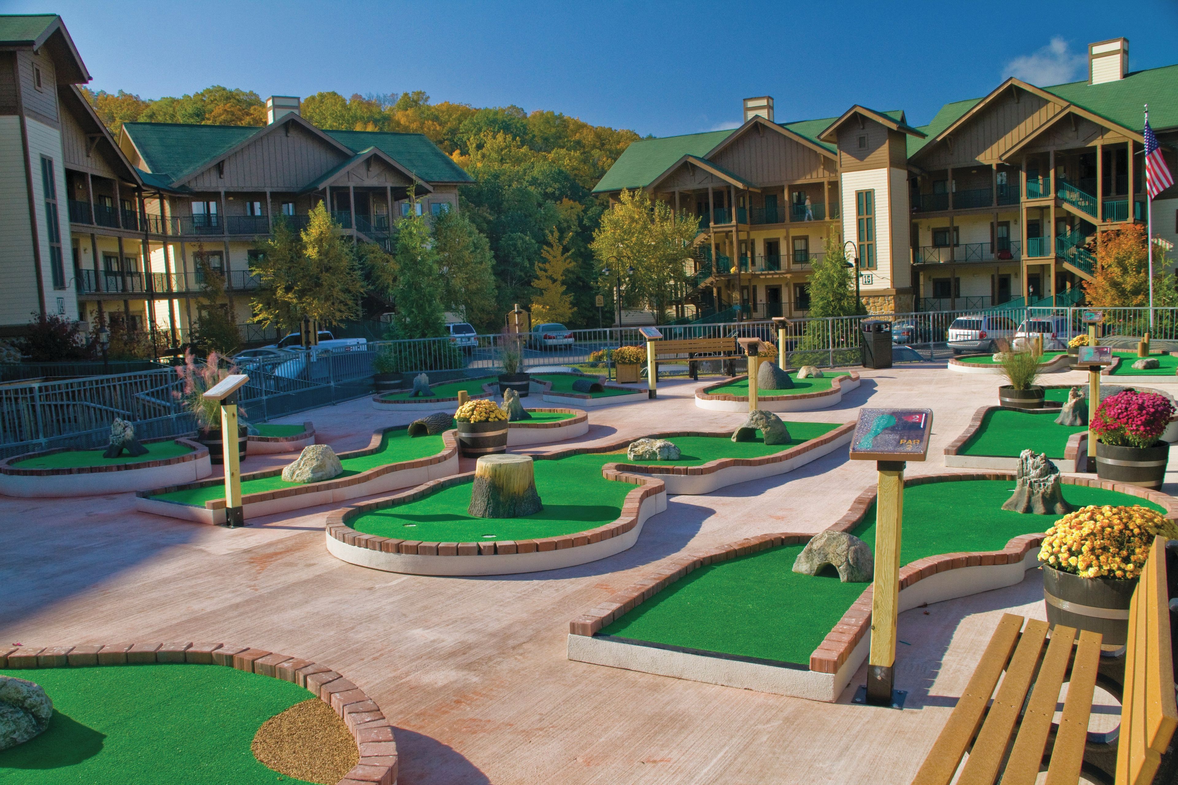 A resort with multiple-story buildings, landscaped gardens, and a parking area.