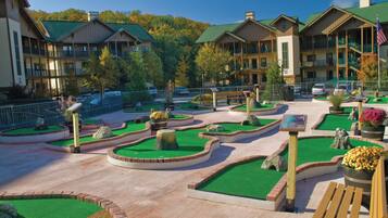 A resort with multiple-story buildings, landscaped gardens, and a parking area.