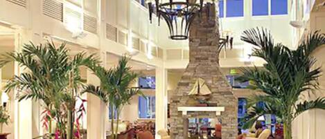 A spacious lobby with high ceilings, a stone fireplace, and multiple seating areas.