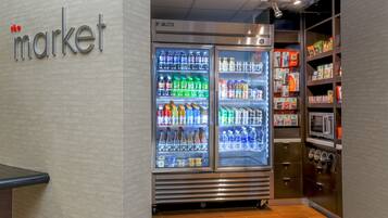 Een koelvitrine met diverse dranken en een plank vol verpakte producten.