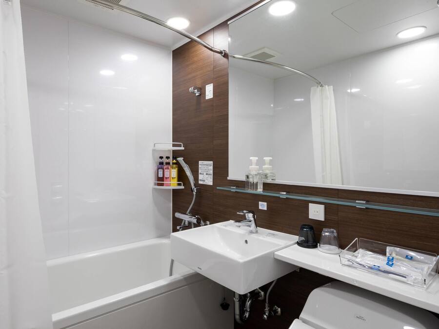 A modern bathroom with a bathtub, a sink, and a mirror.