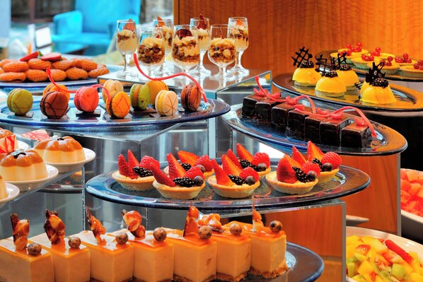 Una variedad de postres y pasteles expuestos en estantes escalonados.