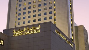 Un grand immeuble d’hôtel aux fenêtres illuminées, sur lequel on peut lire l’inscription « Arraya Ballroom ».