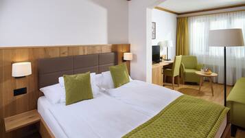 Habitación de hotel con una cama grande, un escritorio, una silla y un televisor.