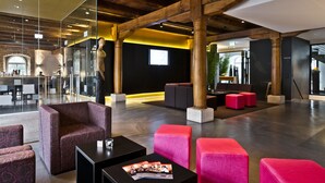 A spacious lobby with a modern design, featuring a mix of seating areas and a reception desk.