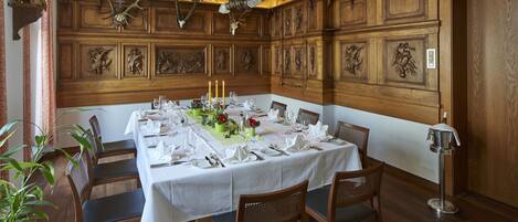 A dining room with a long table set for six, surrounded by wooden chairs.