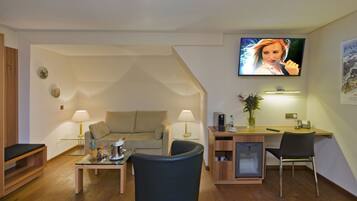 A modern living room with a sofa, coffee table, and a TV mounted on the wall.