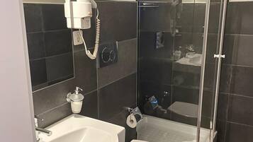Une salle de bain moderne avec un lavabo, des toilettes et une douche à parois de verre.