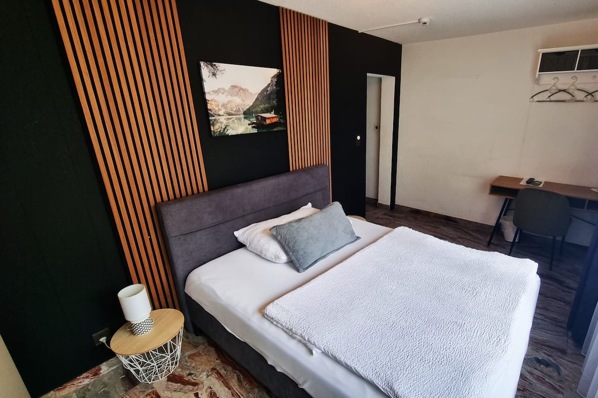 Un dormitorio con una cama, un escritorio y una silla.