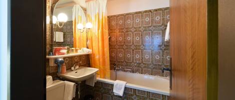 A bathroom with a toilet, sink, and bathtub.