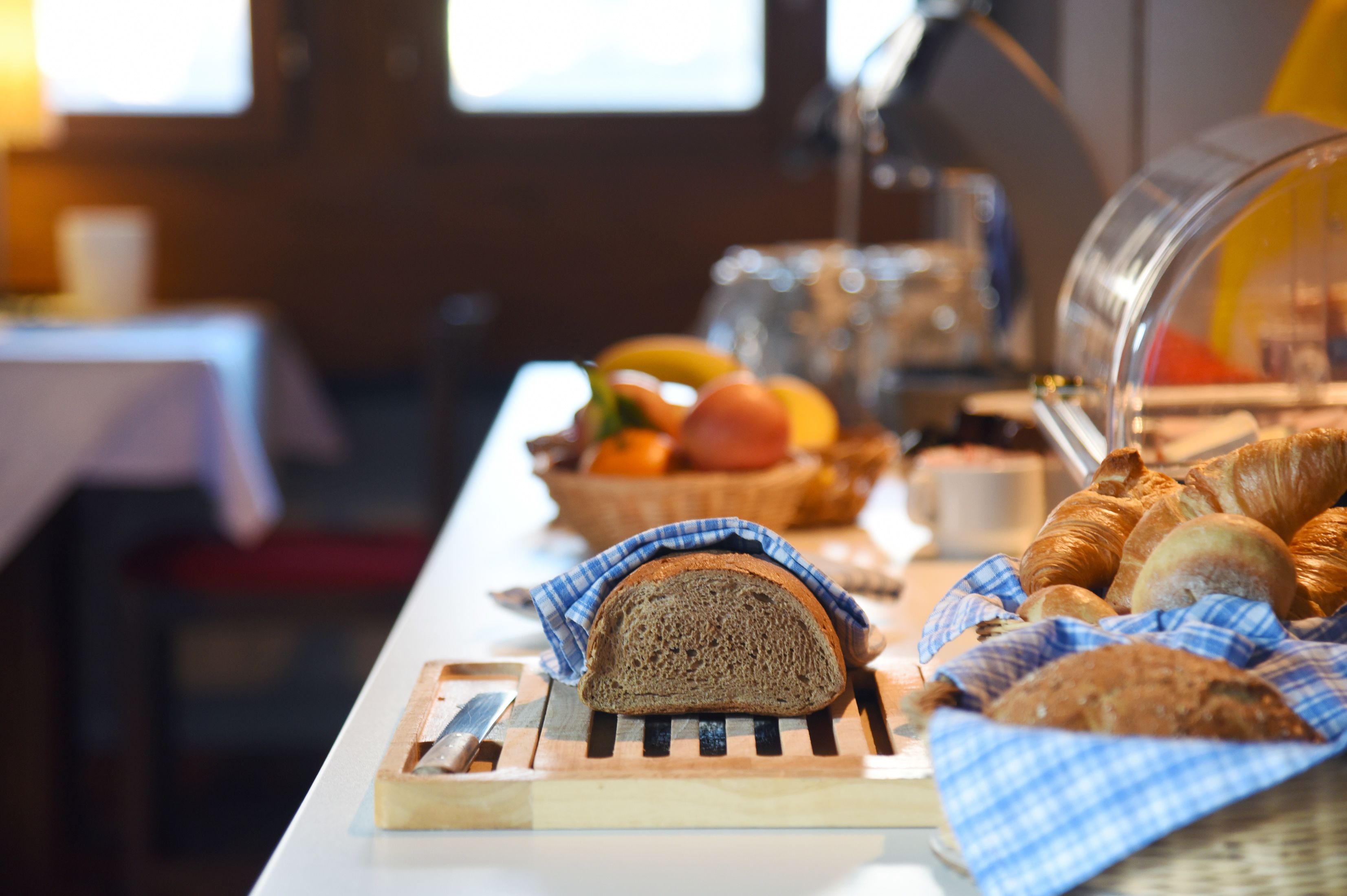 Ein reichhaltiges Frühstücksbuffet mit Brot, Gebäck und Früchten.