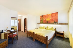 Relax in a cozy space with a double bed, desk, and comfortable seating area.