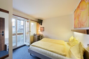 Relax in this inviting space with a large bed, desk, and TV, plus a sliding door to an outdoor area.
