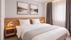 A hotel room with a large bed, two bedside tables with lamps, a headboard, and two framed pictures on the wall. - Hotel Drei Könige (Chur)