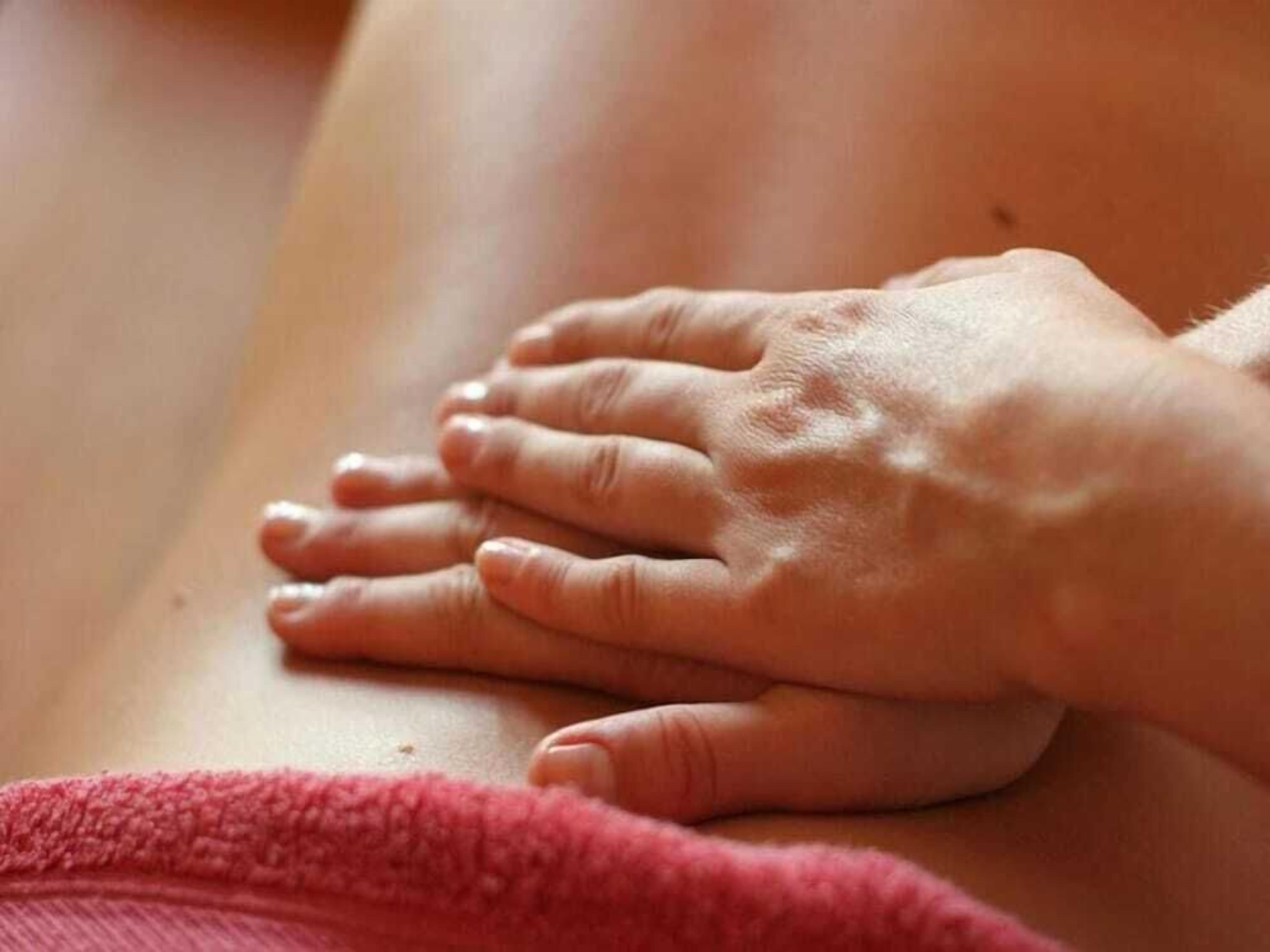 A close-up of hands resting on a wooden surface.