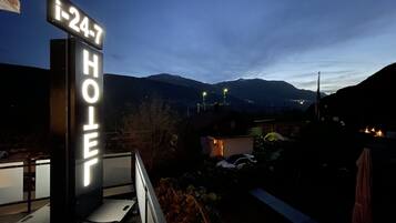 A hotel sign with the number "i-24-7" and the word "HOTEL" illuminated against a night sky.