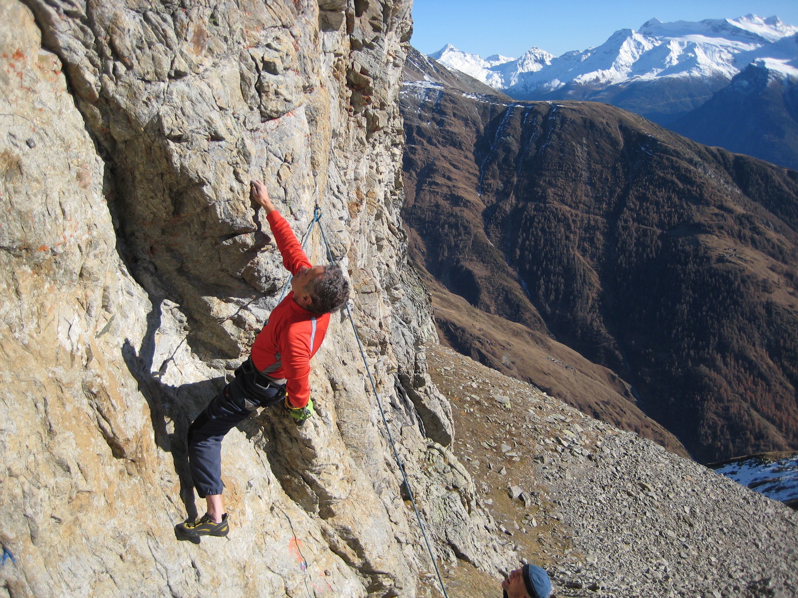 Una persona escalando una montaña rocosa.