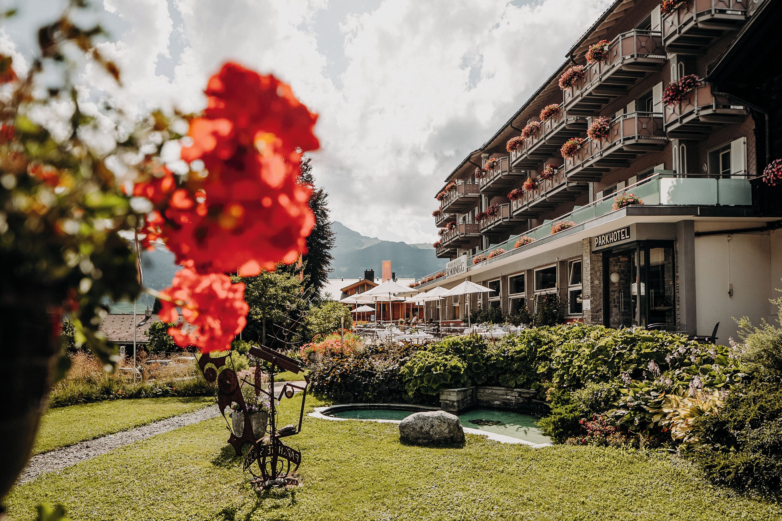A hotel with a garden, a pool, and mountain views.