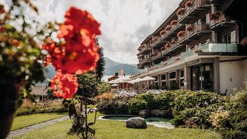 Un hôtel doté d’un jardin, d’une piscine et offrant une vue sur les montagnes.