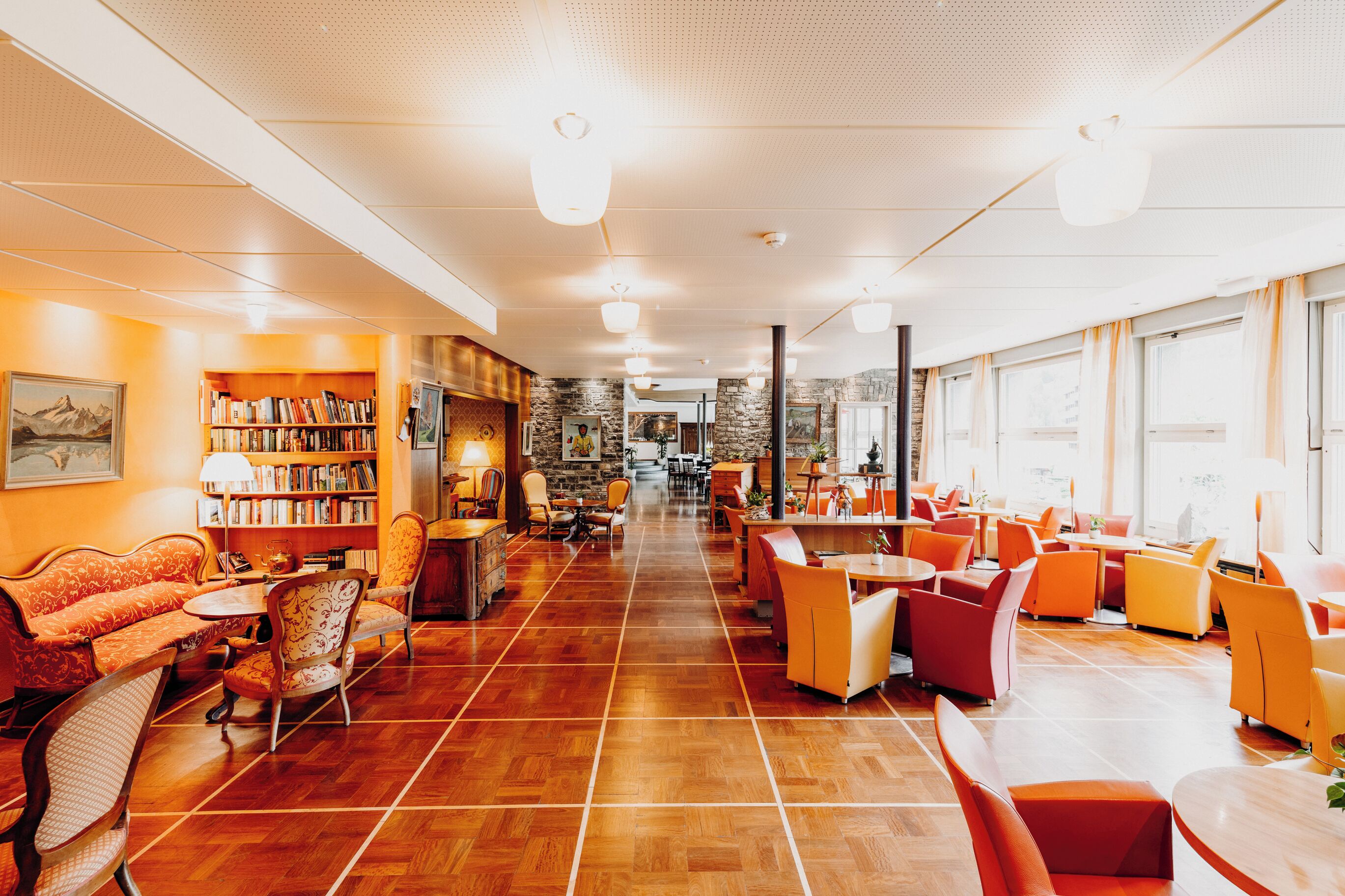 A spacious library with bookshelves, comfortable seating, and large windows.