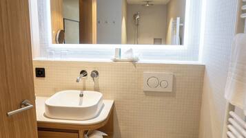 Ein kleines Badezimmer mit Waschbecken, Toilette und Spiegel.