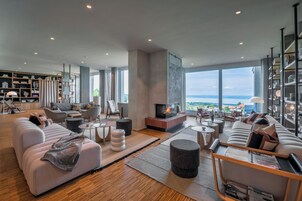 Amplia sala de estar con chimenea, asientos cómodos y vista al océano.