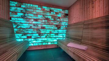 Una sala de sauna con bancos de madera y una pared con textura.
