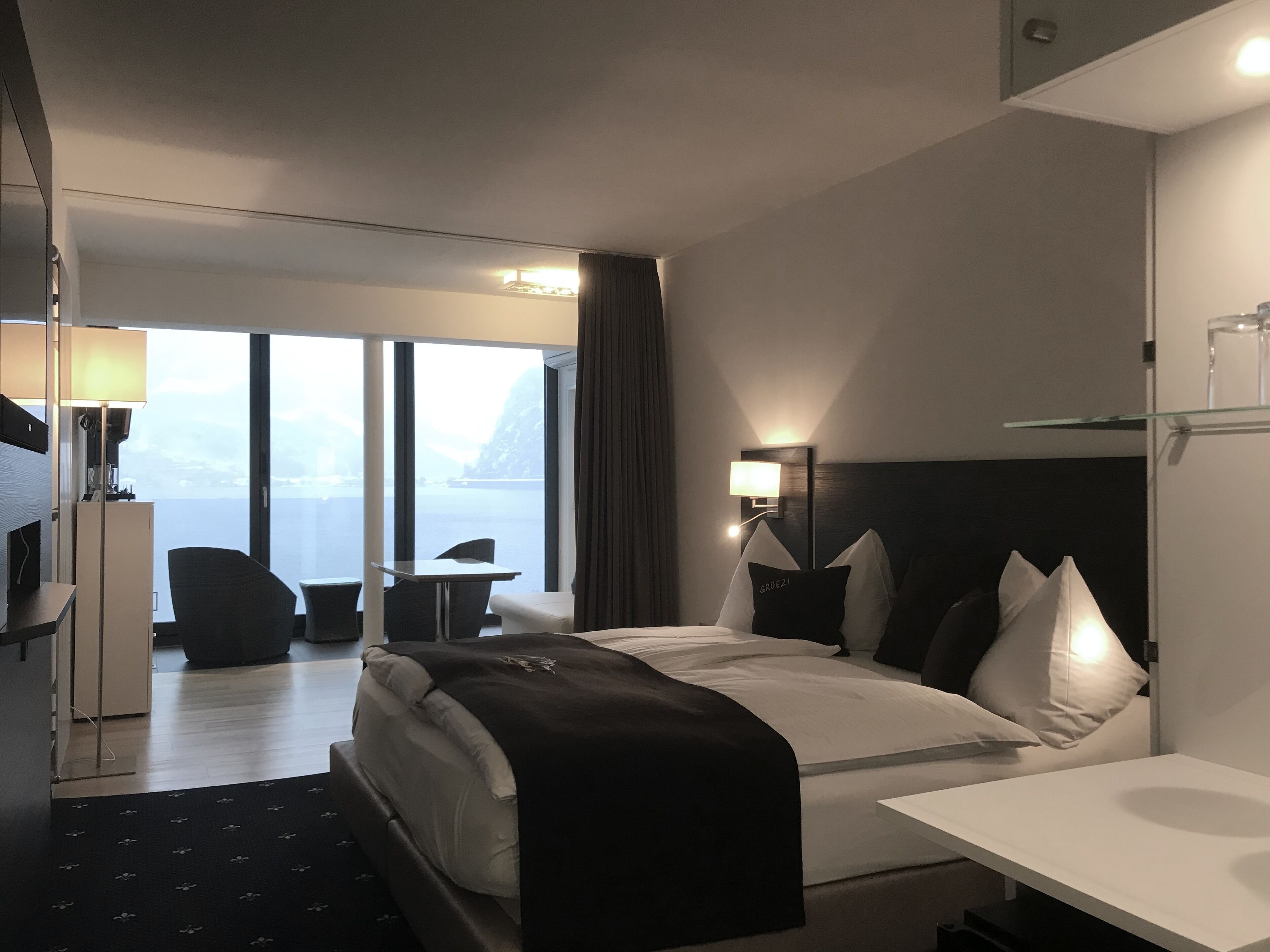 Ein modernes Hotelzimmer mit einem großen Bett, einem Schreibtisch und Blick auf das Meer.