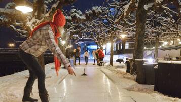 Una persona jugando al herradura sobre una superficie de hielo al aire libre de noche.