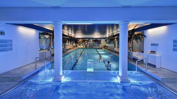 Una piscina techada, sillones reclinables de piscina