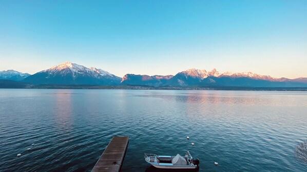 Un lac paisible, avec une jetée en bois et un petit bateau.