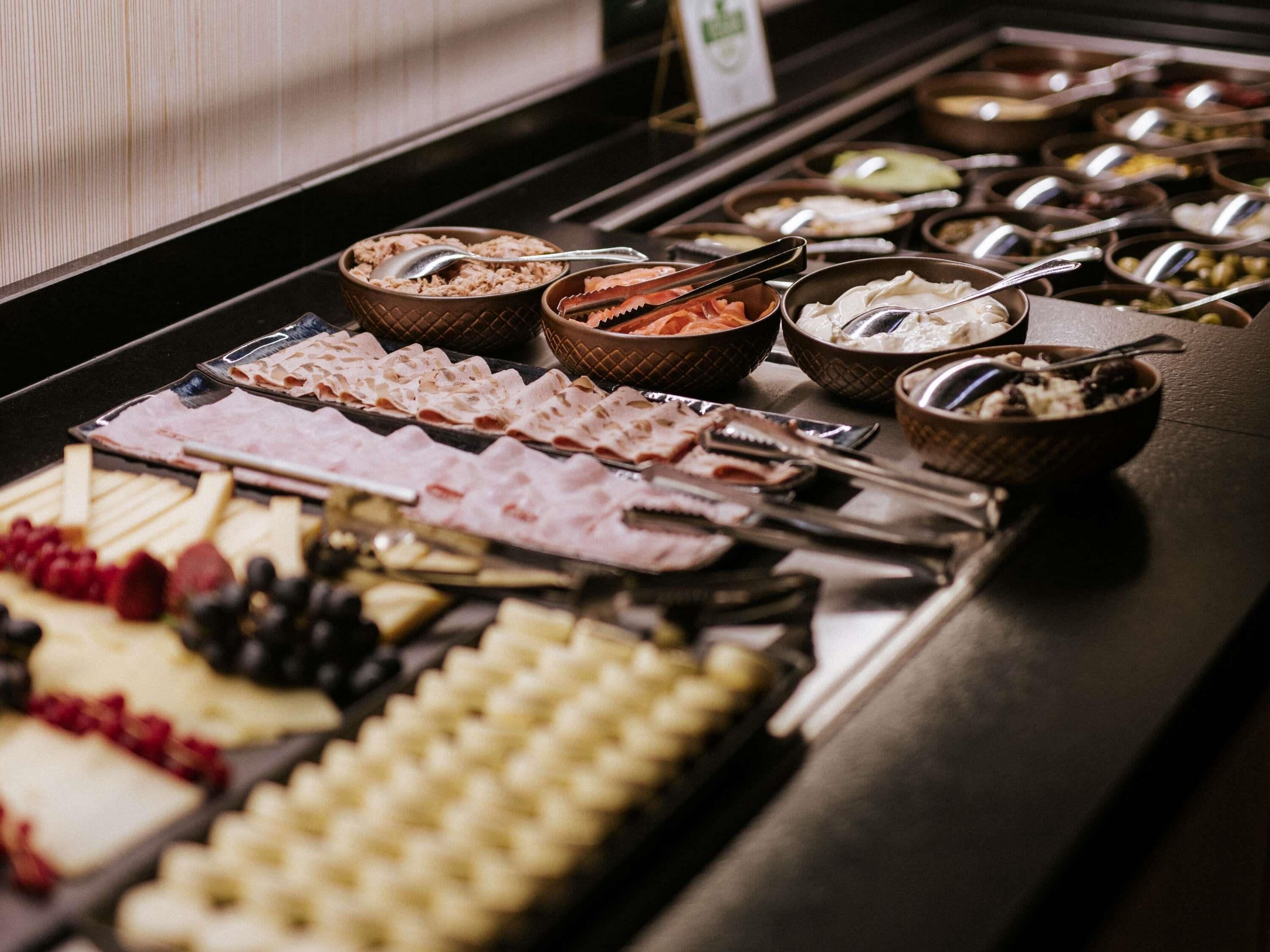 A buffet with various food items and utensils.