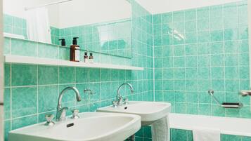 A bathroom with two sinks, a bathtub, and a mirror.