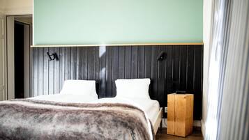 A bedroom with a bed, a wooden nightstand, and a headboard with vertical slats.