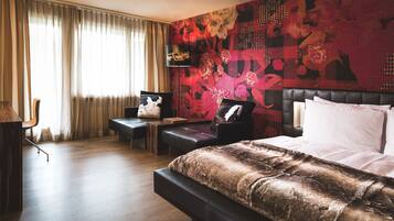 Ein modernes Hotelzimmer mit einem großen Bett, einem Schreibtisch und einem Stuhl.