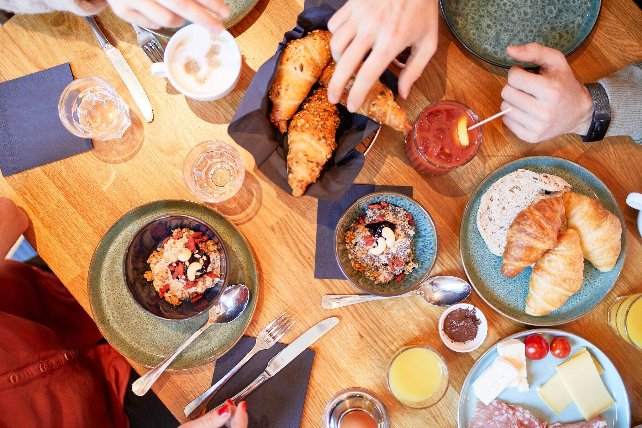 Una mesa de comedor con diversos alimentos y cubiertos.